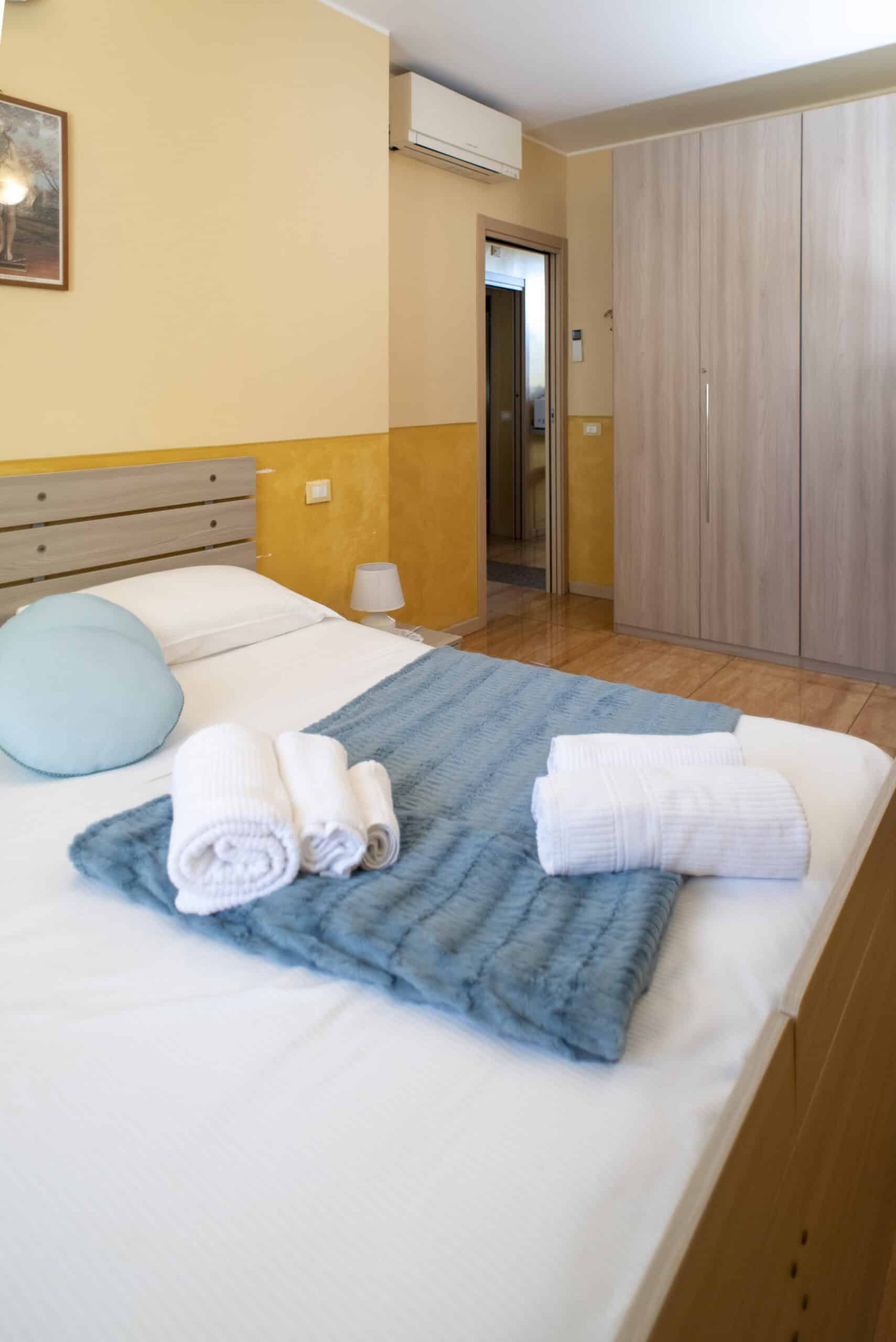 camera con letto e asciugamani ordinati